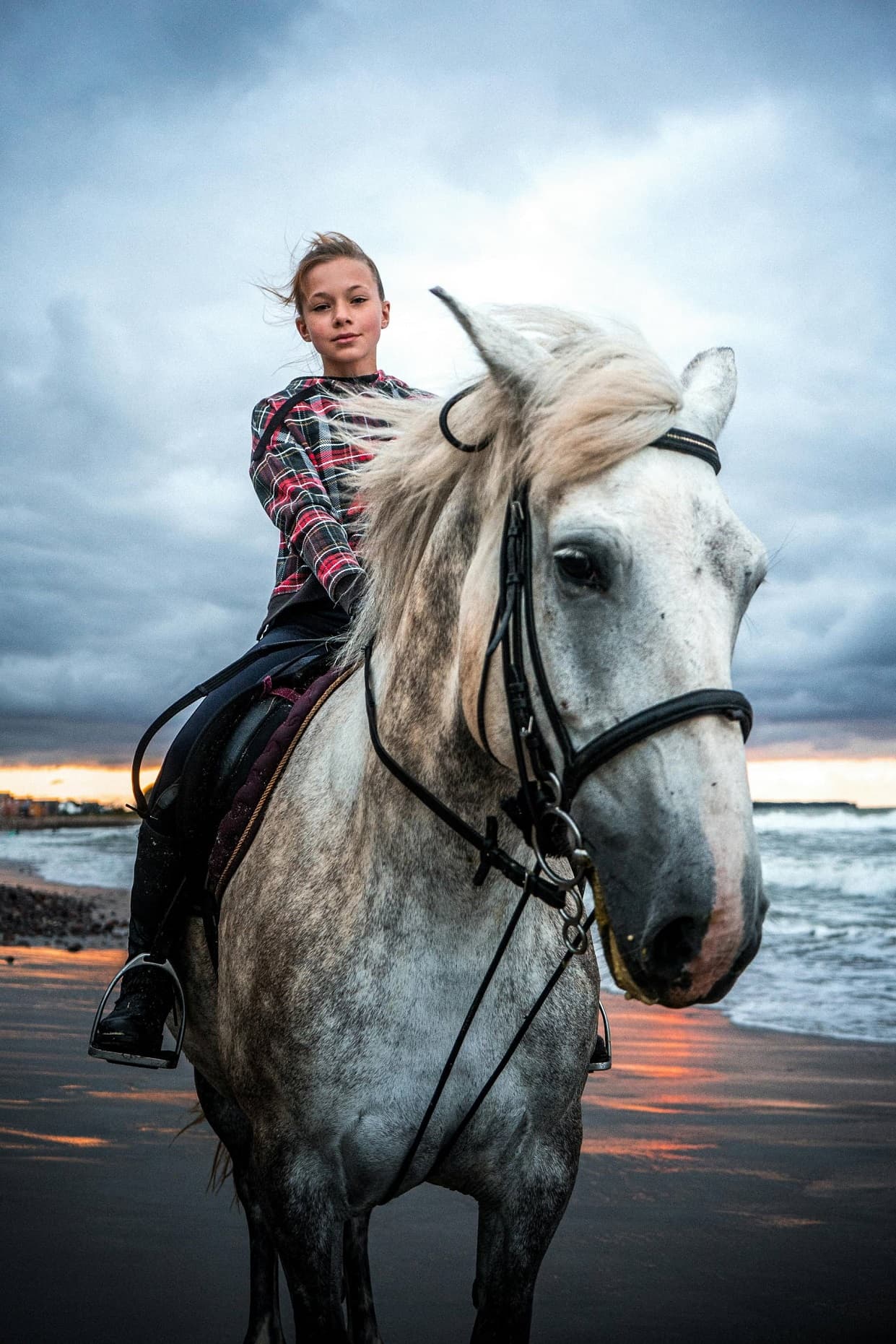 Девочка-подросток сидит на белой лошади