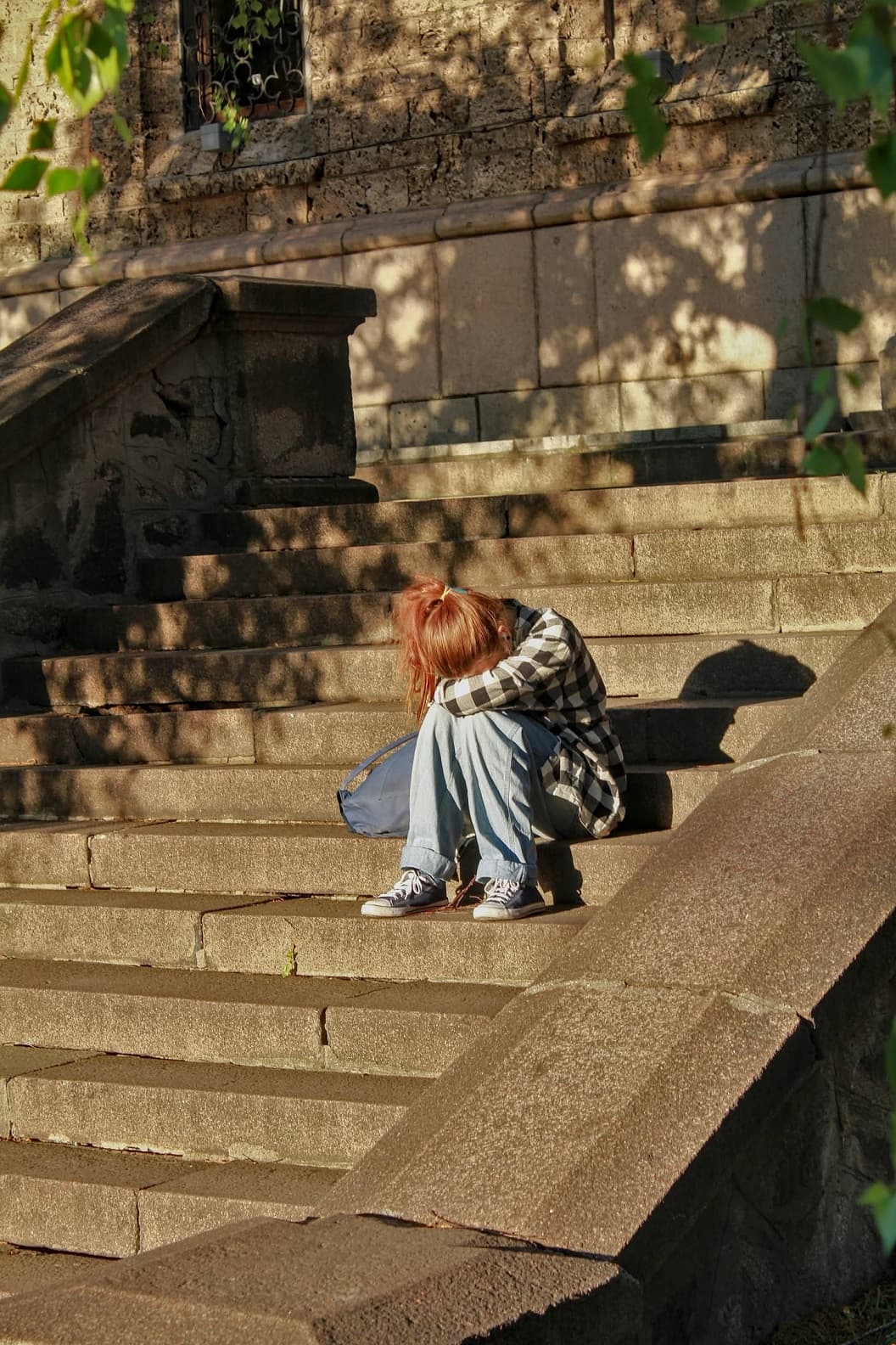 Сумна дівчинка-підліток сидить на сходах